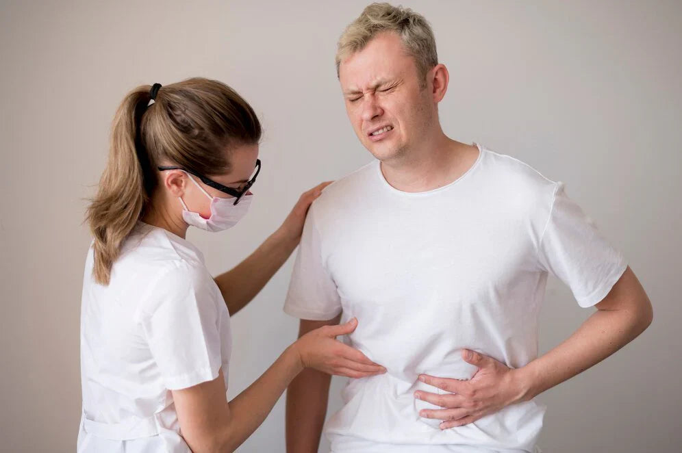 Healthcare professional examining a man experiencing abdominal pain, a potential symptom of Atherosclerosis Abdominal Aorta.