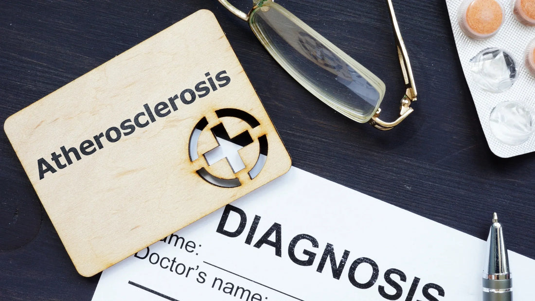 A wooden plaque with the word "Atherosclerosis," a diagnosis form, glasses, and pills on a table, symbolizing medical and natural approaches, including nattokinase and serrapeptase, for cardiovascular health